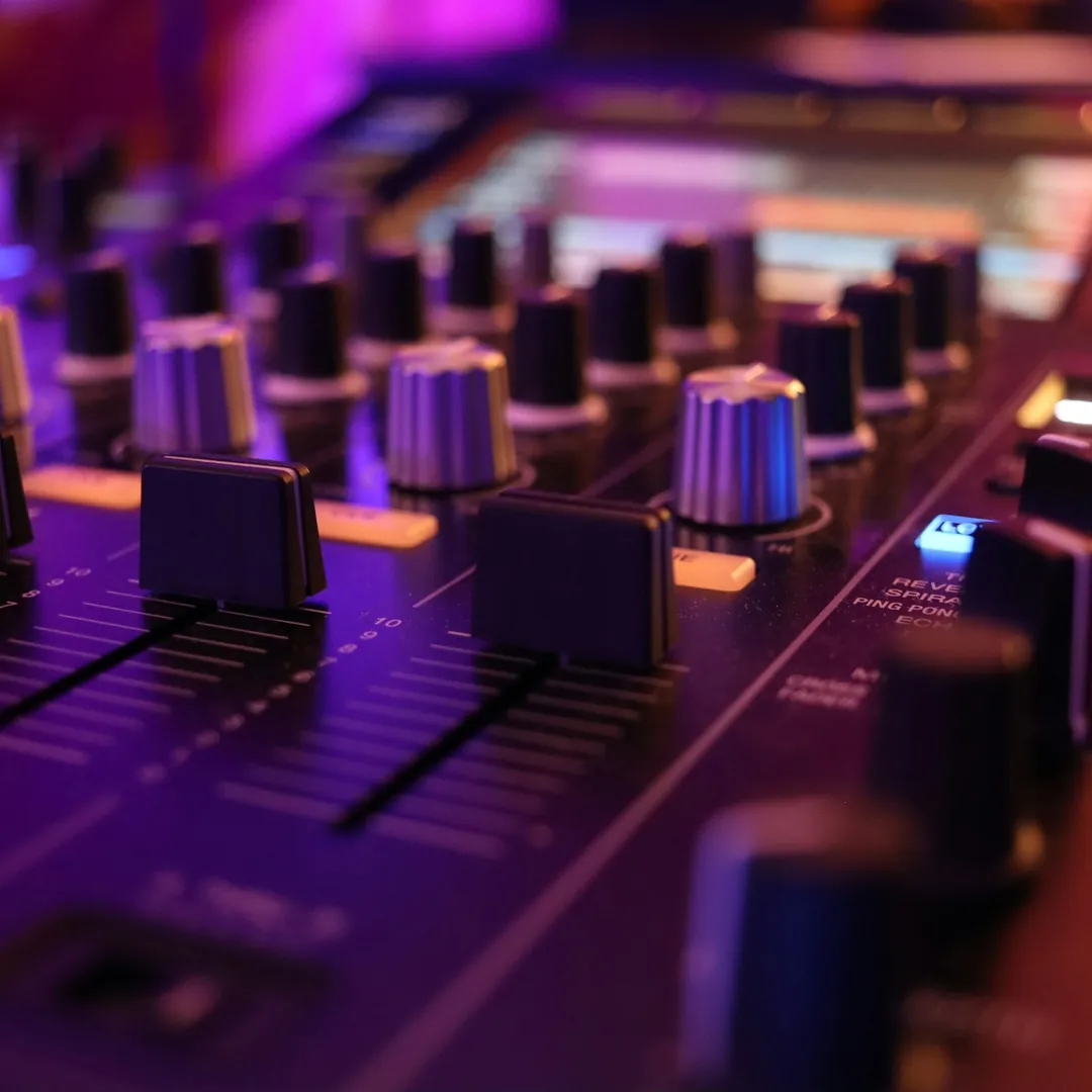Mesa de mezclas de un estudio de grabación con faders, potenciómetros y vúmetros iluminados